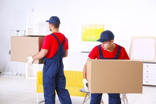 Professional movers preparing an upright piano for removal in Hammersmith