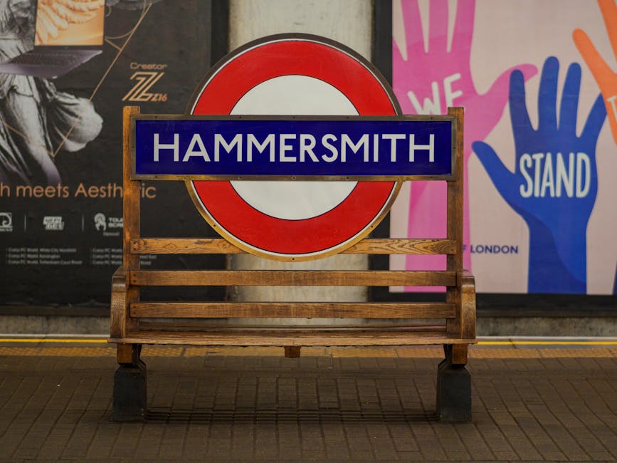 A red double-decker bus displaying the route number 9 and the destination Hammersmith is traveling along a city street in Hammersmith, London, as part of local public transport services. The bus is ap
